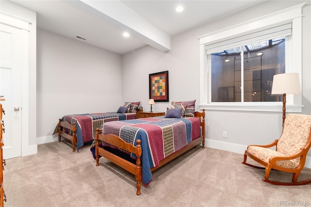 bedroom with beamed ceiling and light colored carpet