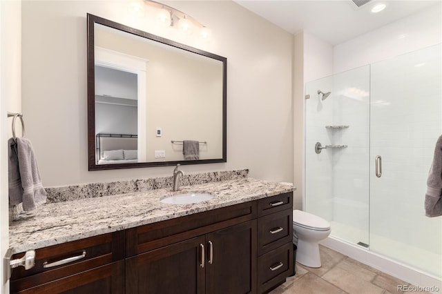 bathroom with vanity, toilet, and a shower with door