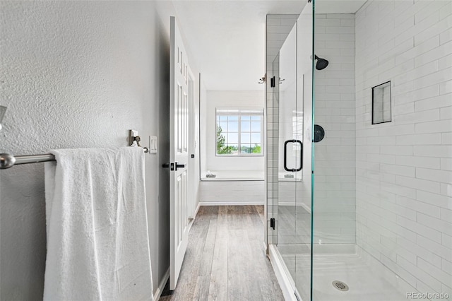 5555 E Briarwood Ave Unit 2604, Centennial, CO 80122 - bathroom featuring wood finished floors, a stall shower, and a textured wall