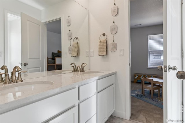 full bath with double vanity, visible vents, and a sink