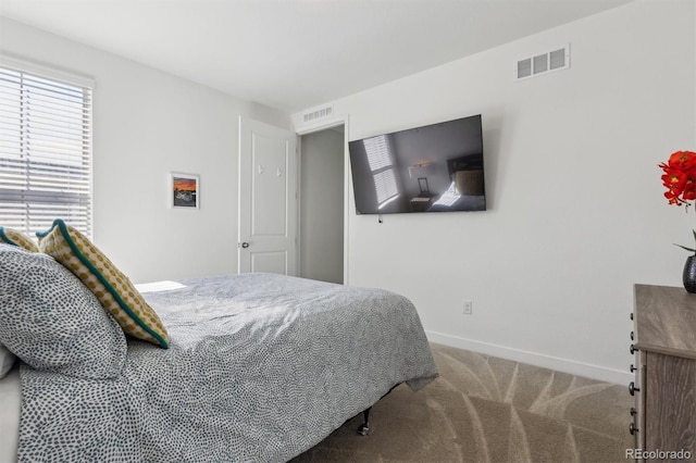 carpeted bedroom featuring visible vents and baseboards