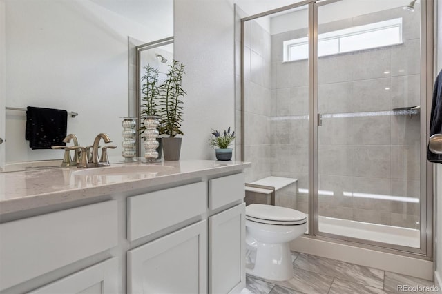 full bathroom featuring toilet, marble finish floor, a stall shower, and vanity