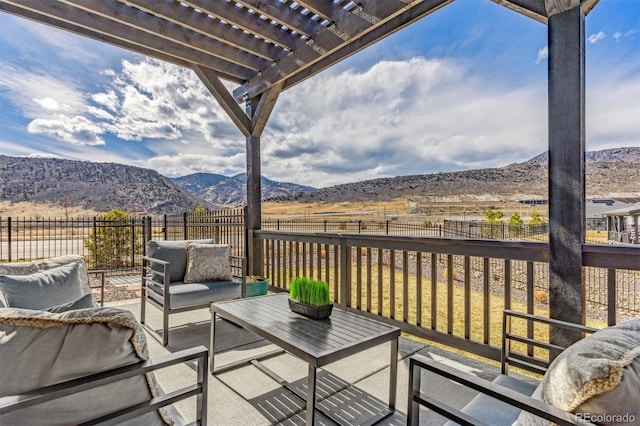 wooden deck with a pergola, a fenced backyard, a mountain view, outdoor lounge area, and a patio area