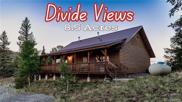 rear view of property with metal roof and log veneer siding