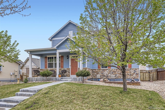 277 Jewel St, Brighton, CO 80603 - view of front of property with fence, covered porch, a front yard, and stone siding