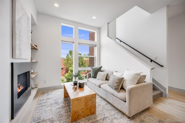 3008 Blake St, Denver, CO 80205 - living room with wood finished floors, stairs, recessed lighting, a warm lit fireplace, and a towering ceiling