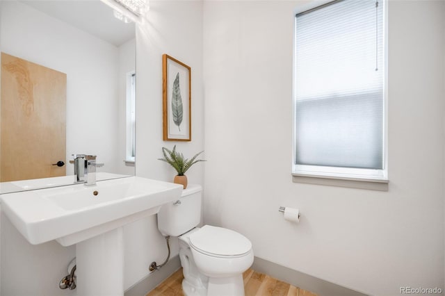 3008 Blake St, Denver, CO 80205 - half bathroom featuring toilet, wood finished floors, and baseboards