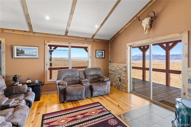 living room featuring a mountain view, wood-type flooring, and vaulted ceiling with beams