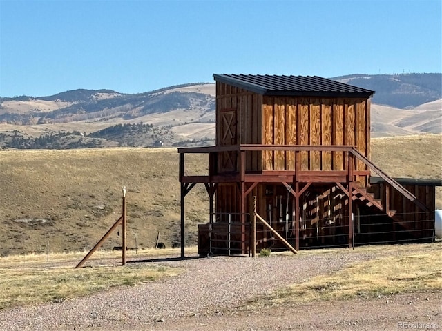 view of jungle gym with a mountain view, a rural view, and an outdoor structure