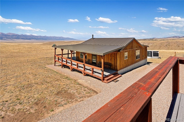 back of property with a deck with mountain view