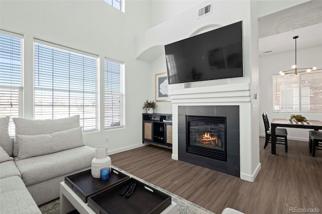 living room featuring dark hardwood / wood-style flooring, a wealth of natural light, and a tile fireplace