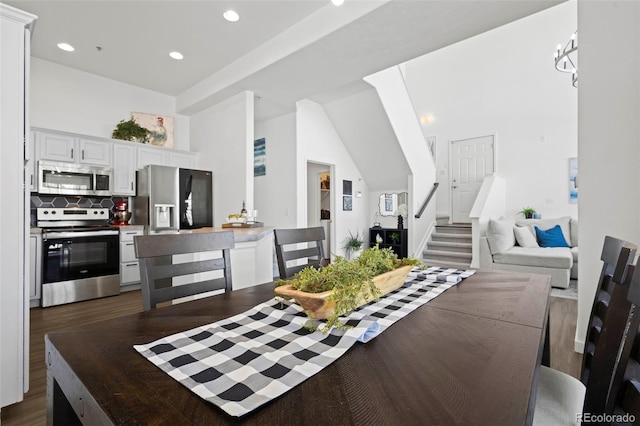 dining space with a high ceiling and dark hardwood / wood-style flooring