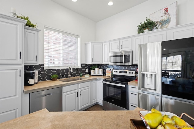 kitchen with sink, white cabinetry, dark hardwood / wood-style flooring, stainless steel appliances, and decorative backsplash