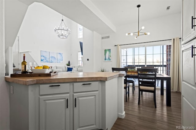 kitchen featuring a notable chandelier, hanging light fixtures, and white cabinets