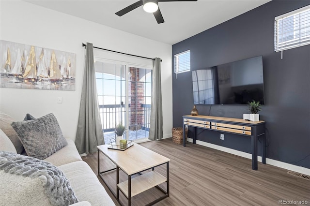 living room with wood-type flooring and ceiling fan