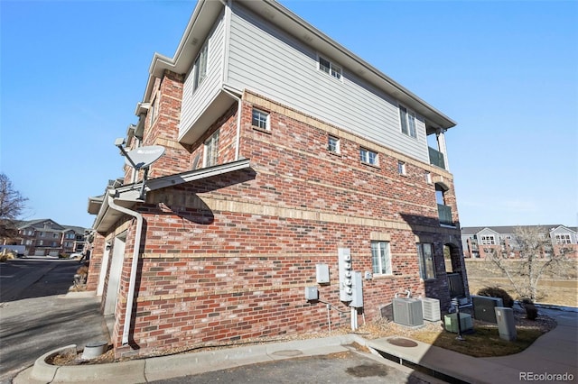 view of side of home featuring a garage and central air condition unit