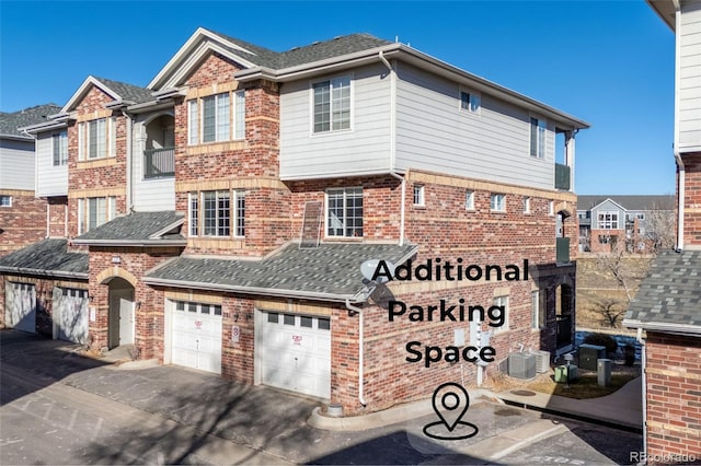 view of front of property featuring central AC and a garage