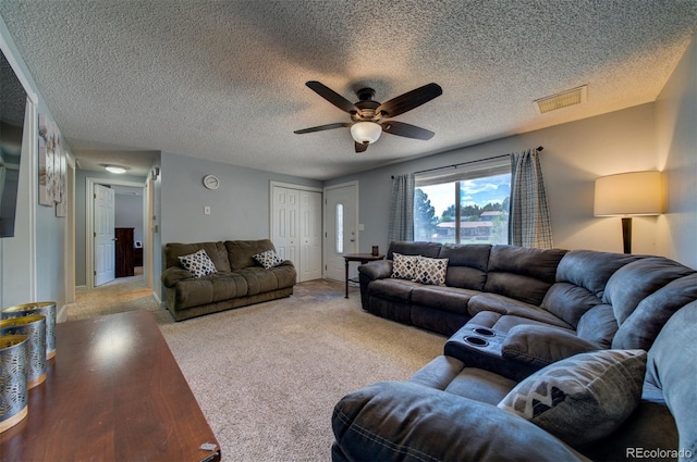 living room featuring carpet, ceiling fan, and a textured ceiling