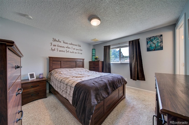 bedroom featuring a textured ceiling and light carpet