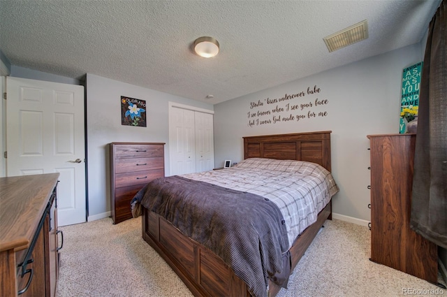 carpeted bedroom with a textured ceiling and a closet