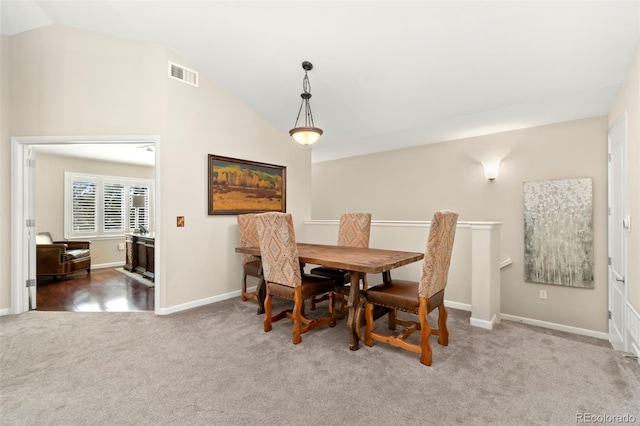 dining area with lofted ceiling, visible vents, dark carpet, and baseboards