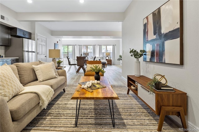 living room with wood-type flooring and beam ceiling