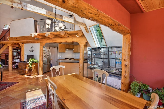 dining room with tile floors, an inviting chandelier, and lofted ceiling with skylight