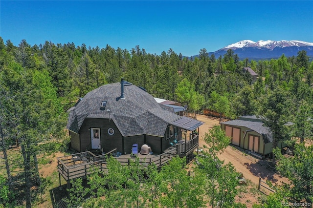 47 Aspen Rd, Woodland Park, CO 80863 - back of property with a view of trees, a shingled roof, and a deck with mountain view