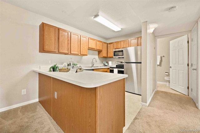 13085 W Cedar Dr Unit 114, Lakewood, CO 80228 - kitchen featuring light countertops, a peninsula, stainless steel appliances, and light colored carpet