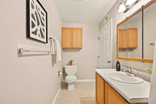 13085 W Cedar Dr Unit 114, Lakewood, CO 80228 - bathroom featuring baseboards, visible vents, toilet, and vanity