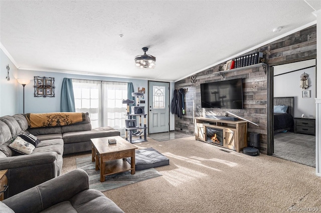 carpeted living room with lofted ceiling, crown molding, a textured ceiling, and a glass covered fireplace