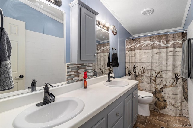 full bathroom with ornamental molding, a sink, toilet, and tasteful backsplash