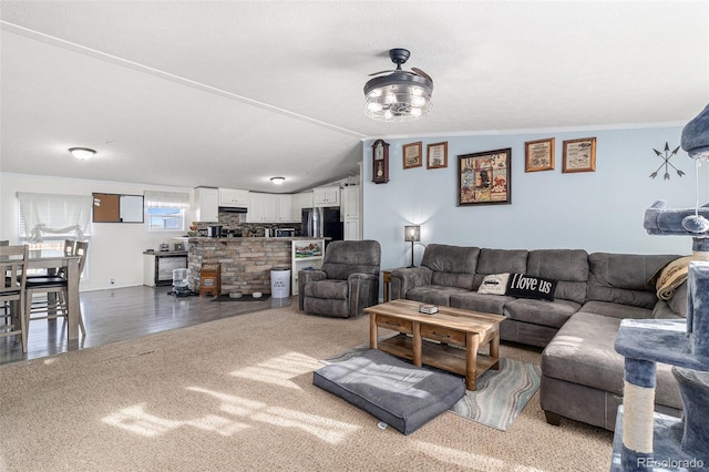 living room featuring vaulted ceiling, wood finished floors, and crown molding