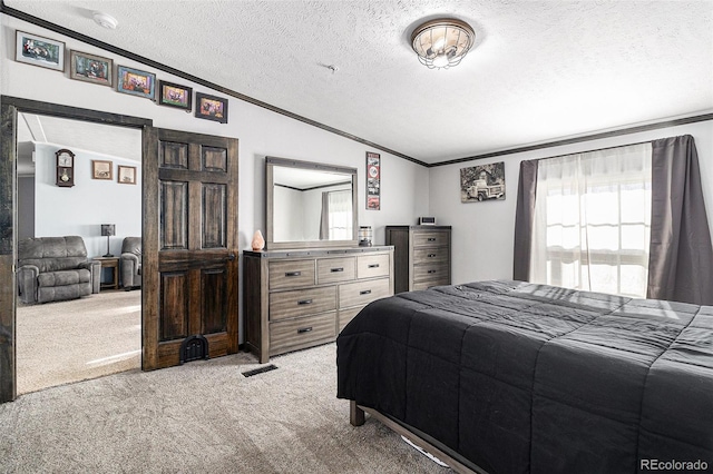 carpeted bedroom featuring a textured ceiling, visible vents, and crown molding