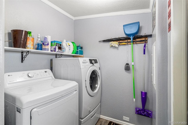 laundry room with laundry area, baseboards, wood finished floors, washing machine and clothes dryer, and crown molding