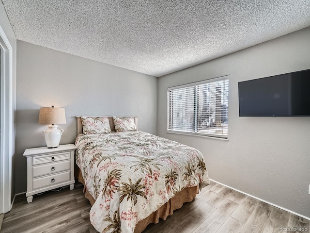 bedroom with wood finished floors and a textured ceiling