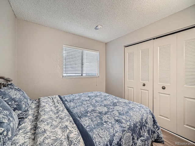 bedroom featuring a closet, a textured ceiling, and wood finished floors