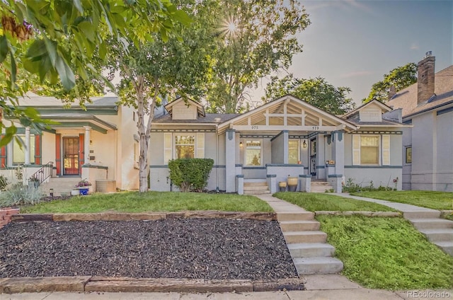 575 N Marion St, Denver, CO 80218 - view of front of house with covered porch, a front yard, and stucco siding