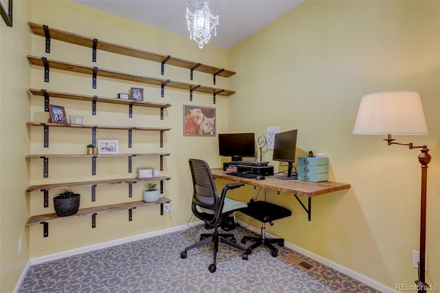 office space with an inviting chandelier and carpet