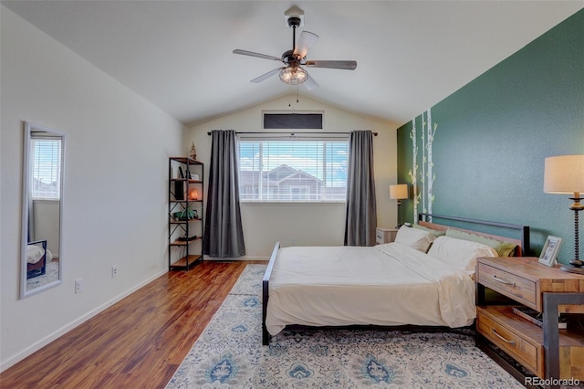 bedroom featuring ceiling fan, dark wood-type flooring, vaulted ceiling, and multiple windows