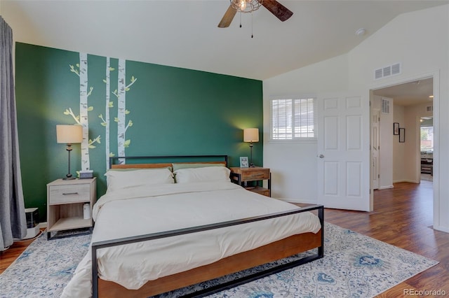 bedroom featuring ceiling fan, multiple windows, lofted ceiling, and wood-type flooring