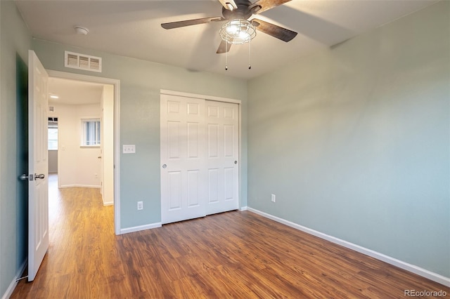 unfurnished bedroom with hardwood / wood-style floors, a closet, and ceiling fan