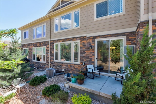 back of property featuring central air condition unit and a patio