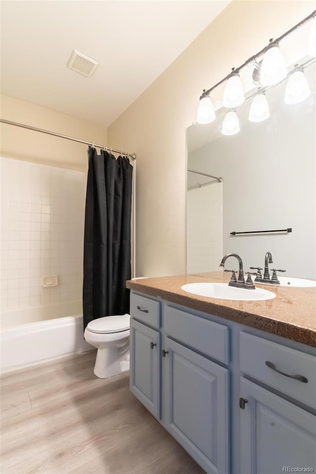 full bathroom featuring shower / bathtub combination with curtain, toilet, vanity, and hardwood / wood-style flooring