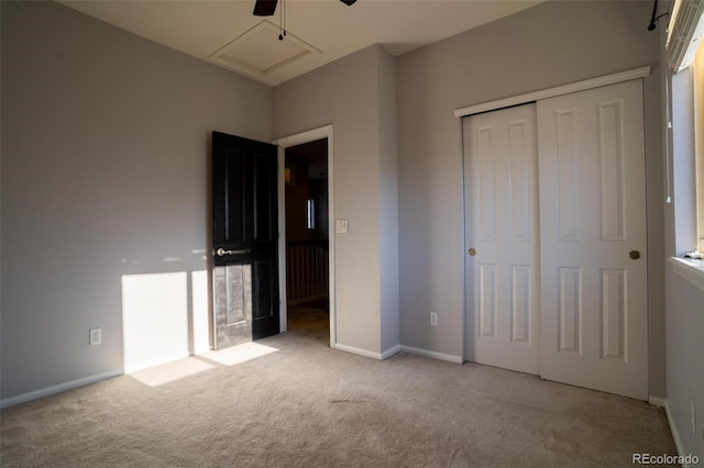 unfurnished bedroom featuring light carpet, a closet, and ceiling fan