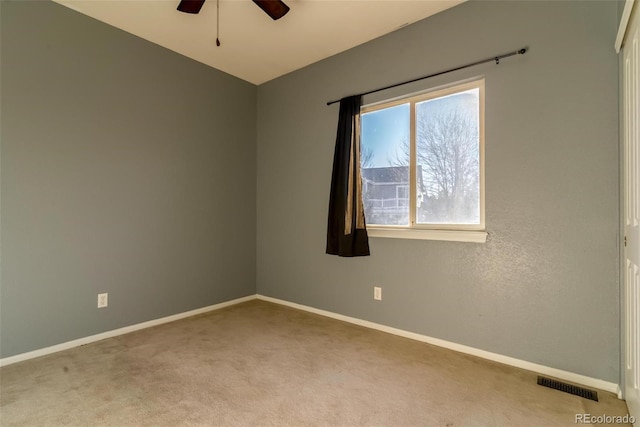 carpeted spare room with ceiling fan