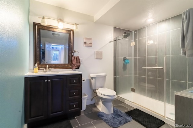 bathroom featuring tile patterned floors, vanity, an enclosed shower, and toilet