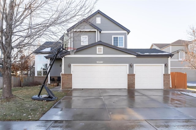 view of front of property featuring a garage, brick siding, concrete driveway, and fence