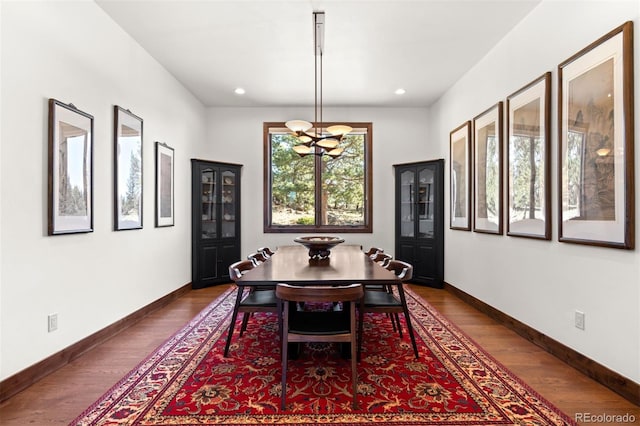 dining space featuring an inviting chandelier and dark wood-type flooring