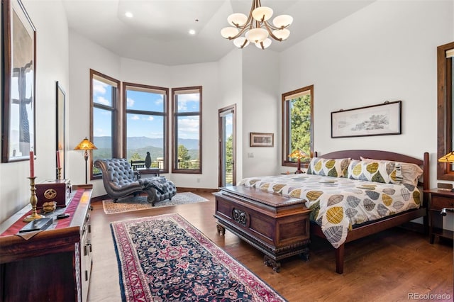 bedroom featuring a chandelier, access to exterior, a mountain view, and hardwood / wood-style floors